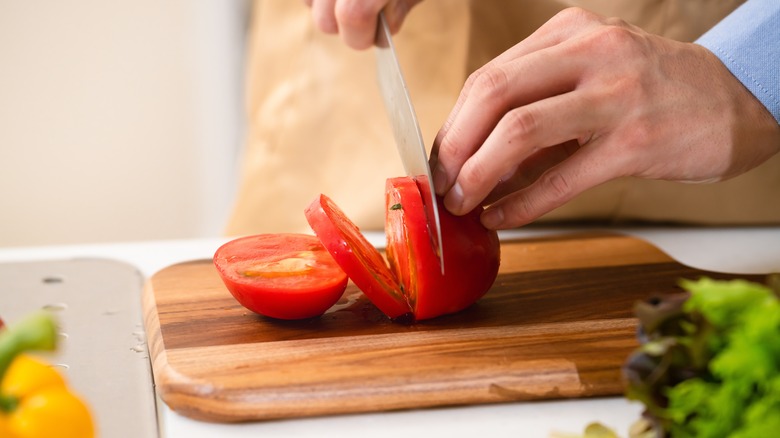 Slicing tomatoes on cutting board