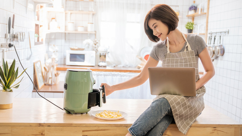 woman using small air fryer