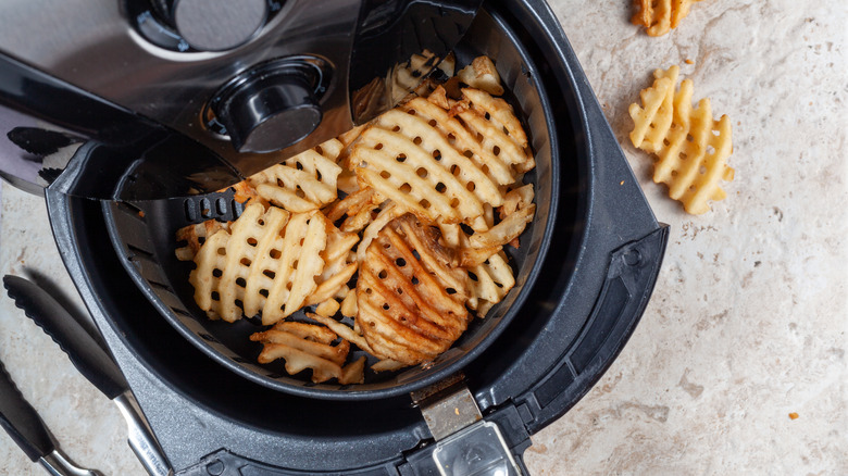 air fryer basket with potatoes