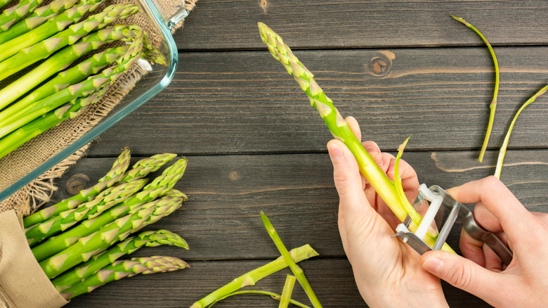 Peeling asparagus on table