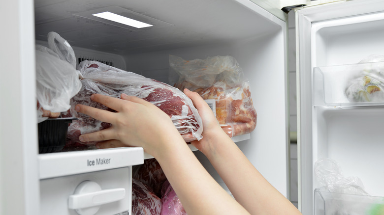 Person taking steak from freezer