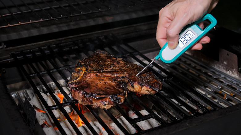 Thermometer checking meat temperature 