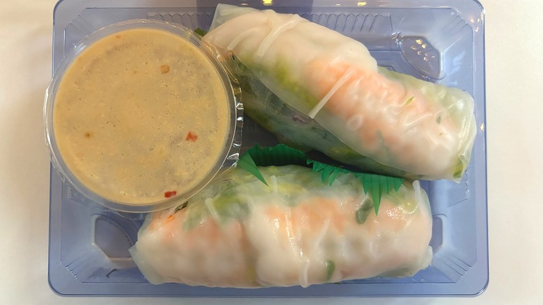 trader joes two shrimp spring rolls with cashew sauce on white table