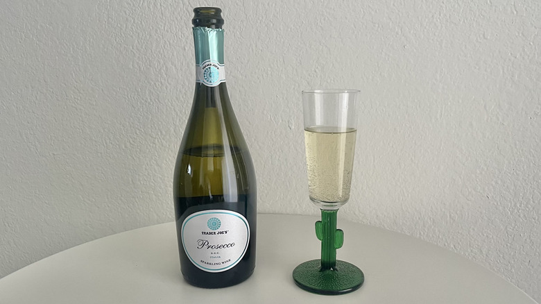 trader joe's prosecco in a glass on a white table