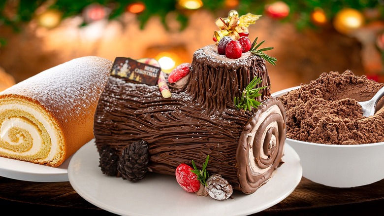 Chocolate and vanilla yule log cake with cocoa powder in bowl