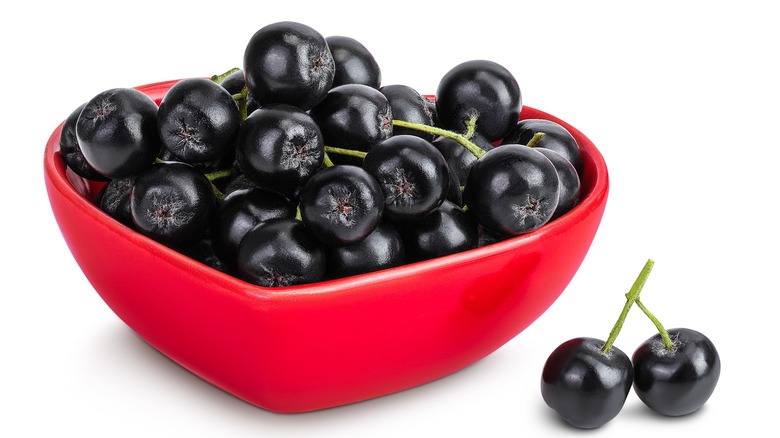 Chokeberries in red, heart-shaped bowl