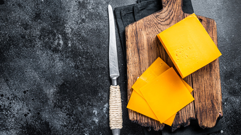 Cheddar cheese on cutting board