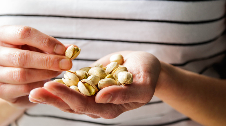 Hands holding pistachios