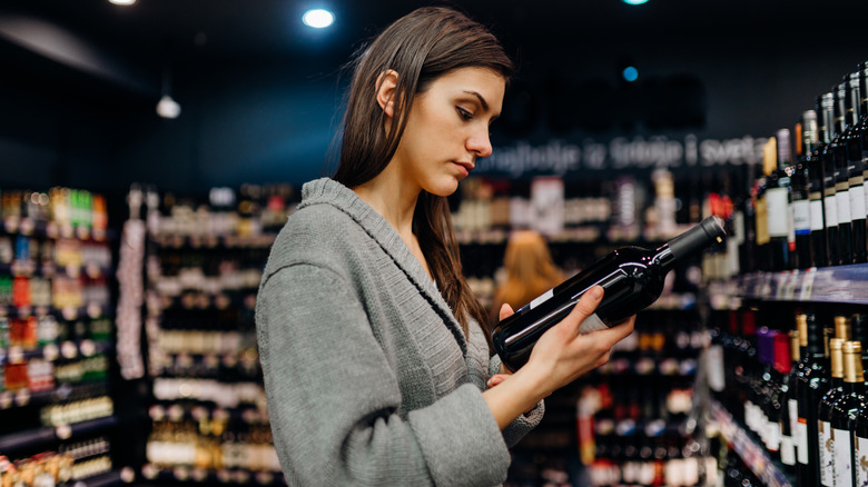 woman looking at wine label