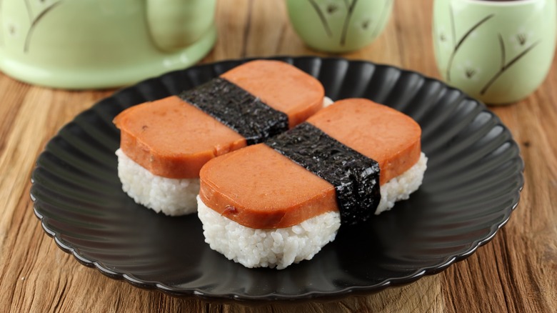 Two pieces of spam musubi on a black plate