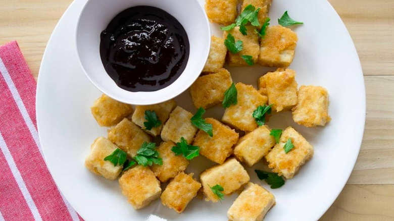 Chopsticks holding fried tofu