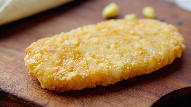 Single hash brown on wooden board