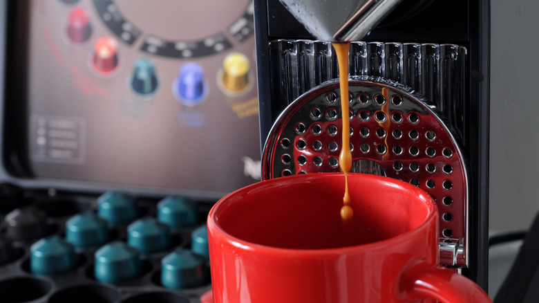 A Nespresso machine next to an assortment of pods