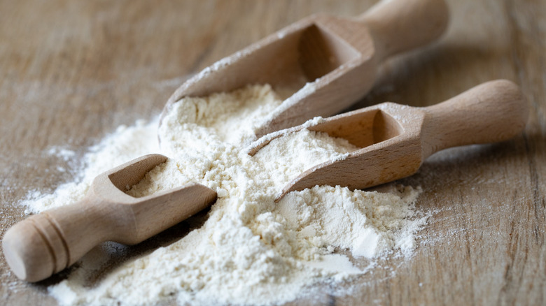 Flour with brown wooden spoons