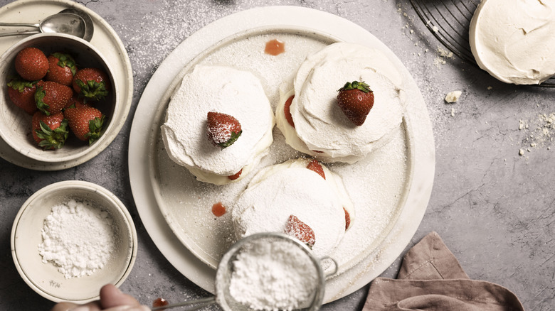 overhead shot of vanilla meringue cookies filled with cream and strawberries