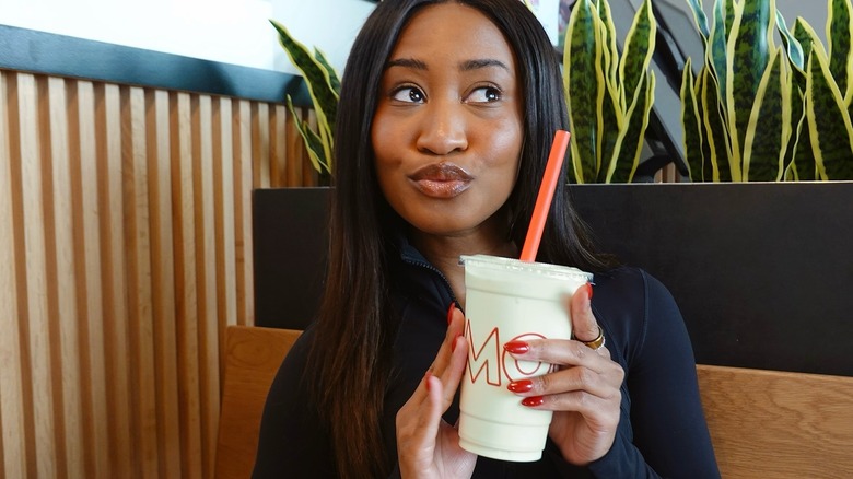 Woman holding a Matcha milkshake from Mooyah