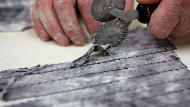 Cutting fresh squid ink pasta 