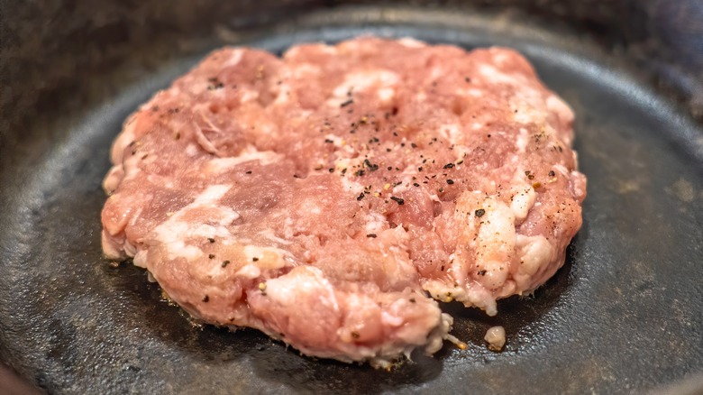 Cooking pork sausage patty in pan