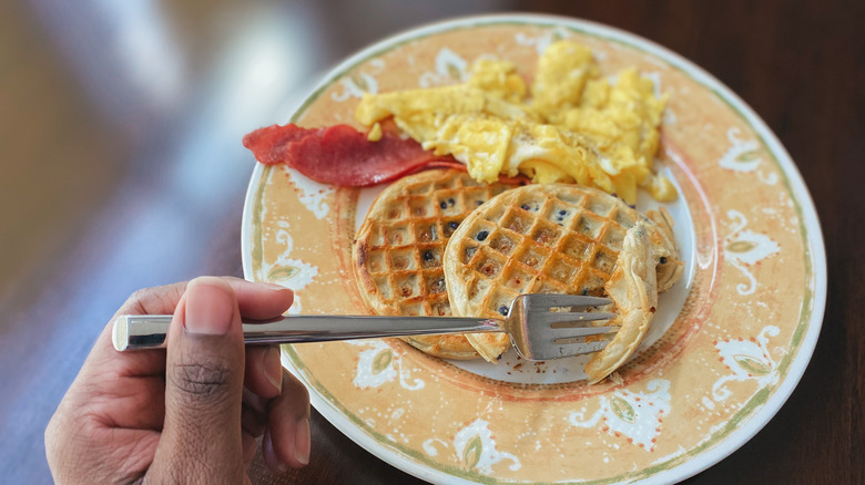 Frozen waffles on plate with eggs and bacon