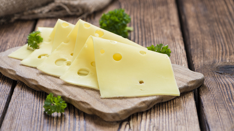 Cheese slices on a wooden cutting board