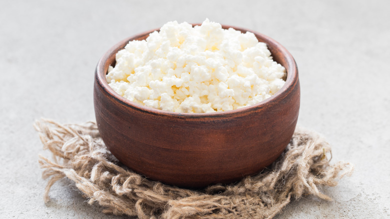 Cottage cheese in wooden bowl on woven material