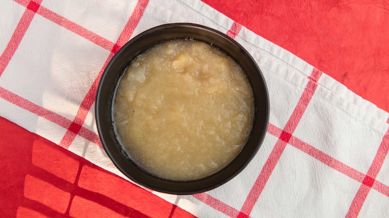 Applesauce in black bowl on red and white tablecloth