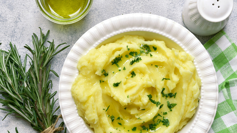 Olive oil drizzled on mashed potatoes topped with chopped parsley