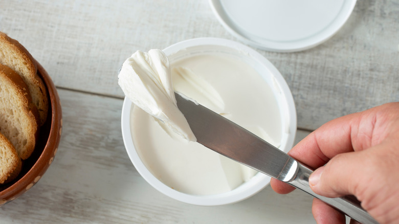 Person using a butter knife to scoop a pat of vegan butter