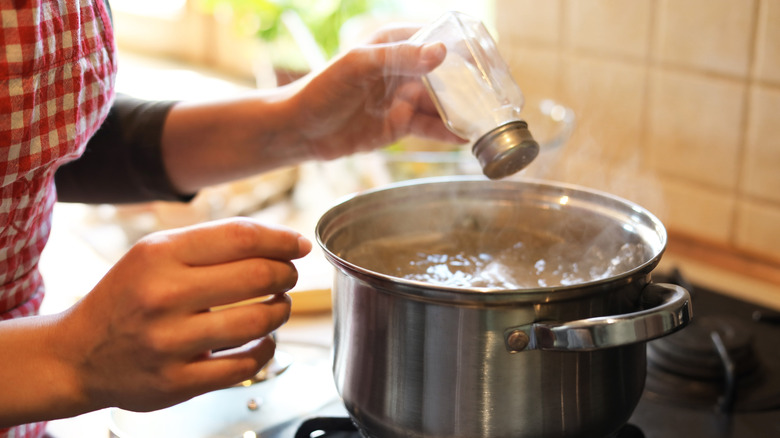 Salt being added to pot of boiling water