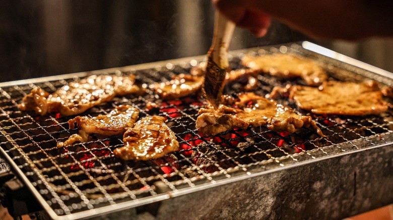 Brush glazing chicken on grill