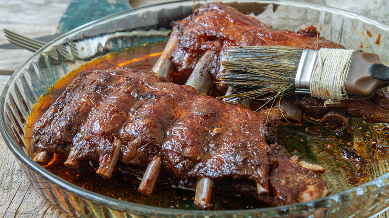 Brushing bourbon whiskey marinade on pork ribs