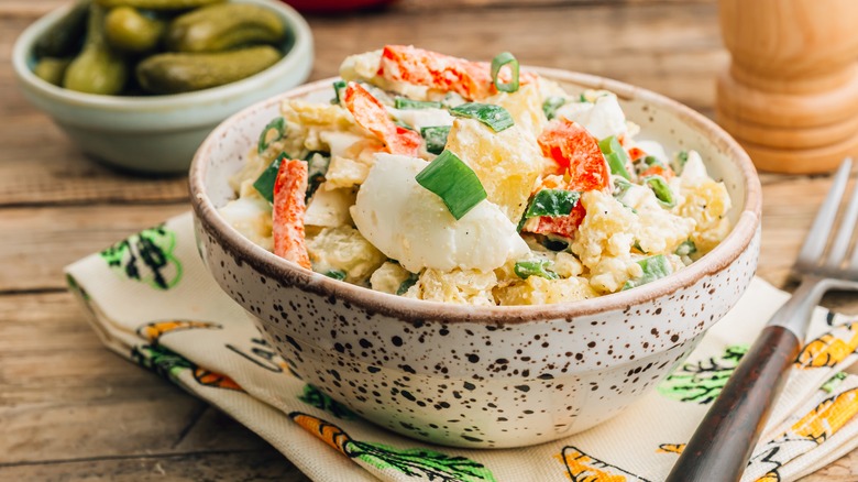 Potato salad bowl with fork and napkin