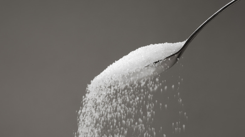 Spoon pouring granulated sugar