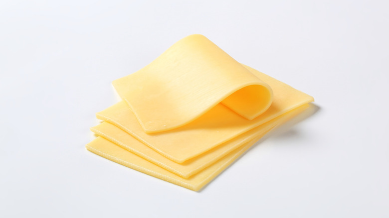 Four slices of cheese on white background