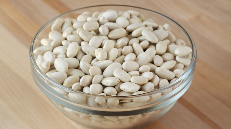 Cannellini beans in glass bowl on wooden table