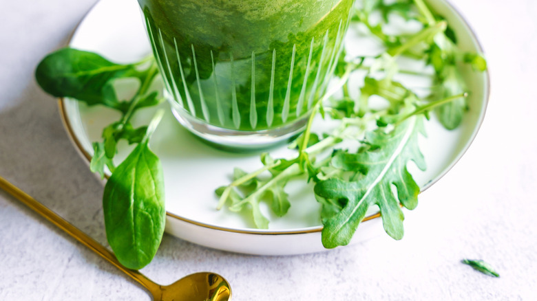 Green smoothie in glass on a plate