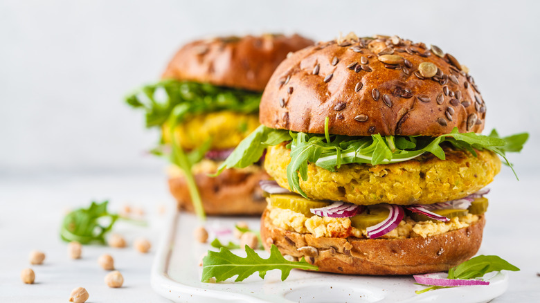 Veggie burger with arugula on white board