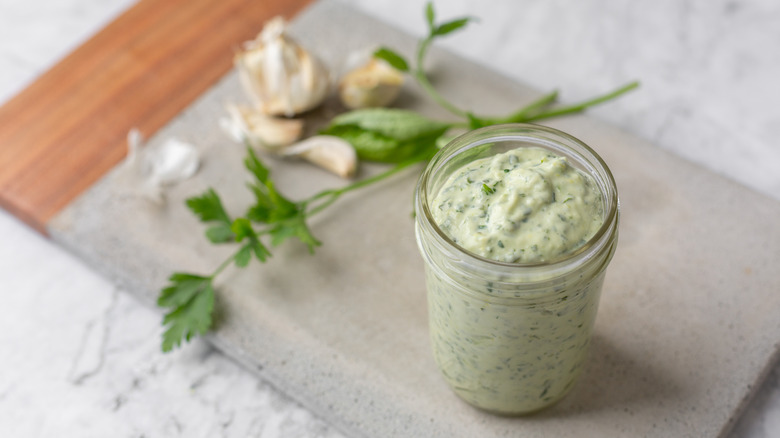 Green goddess dressing in a glass cup
