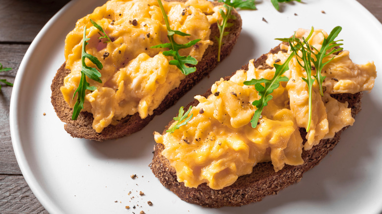 Scrambled eggs with arugula on toast