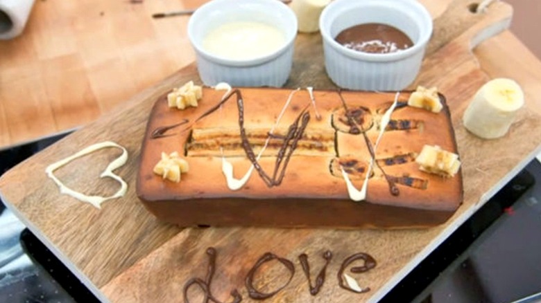 A burnt banana loaf cake with banana stars, chocolate sauce, and caramel drizzled on top