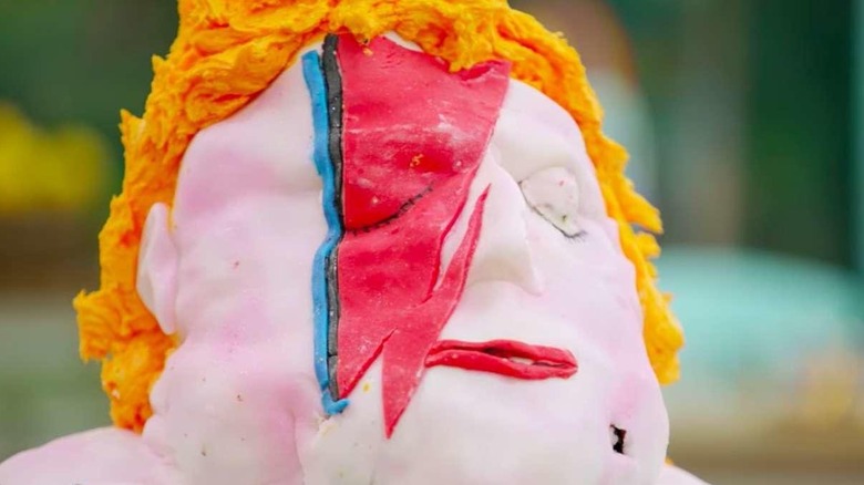 Marc's Ziggy Stardust cake features yellow hair, a lightning bolt image made of red and blue fondant icing over half of the face of the cake that was meant to resemble David Bowie but does not