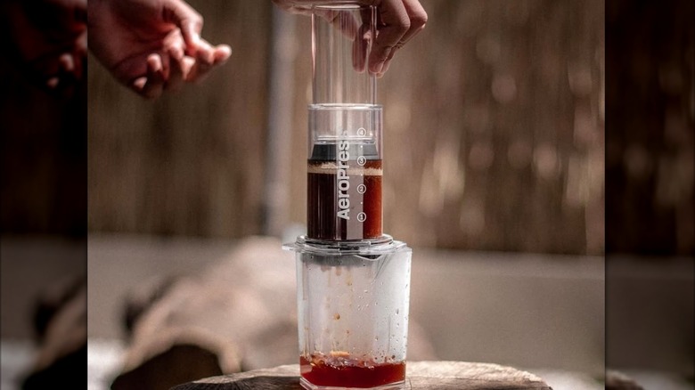 Person brewing coffee with clear Aeropress