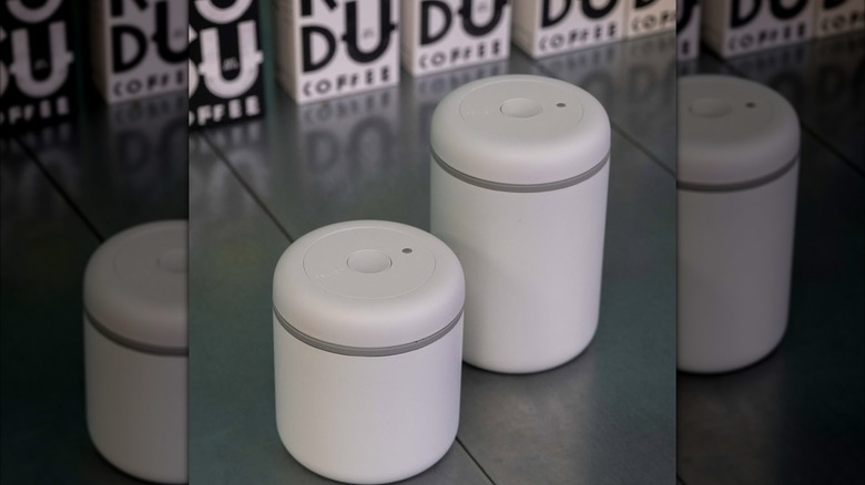 Two white vacuum seal Atmos coffee containers on counter