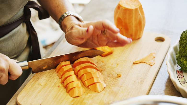 Person chopping sweet potatoes