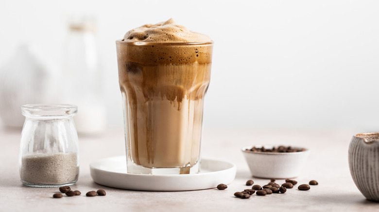 Chocolate coffee drink in glass on white saucer