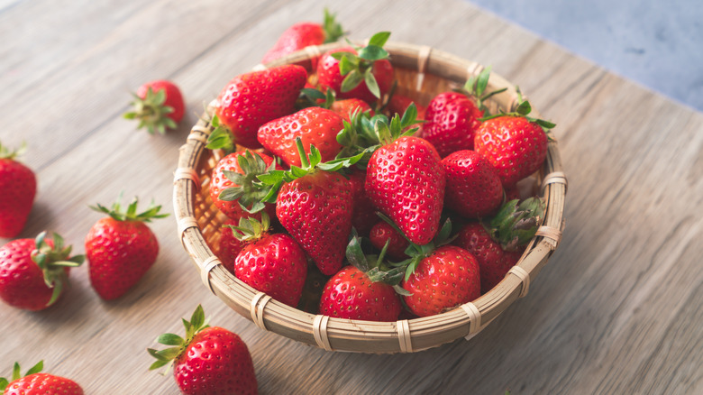 Basket of fresh strawberries on wooden table