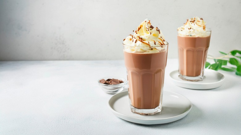 Two chocolate milkshakes with whipped cream