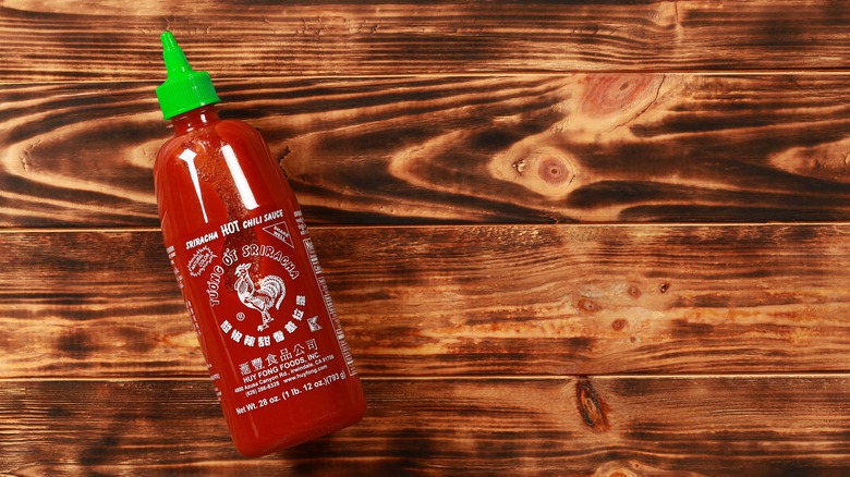 Sriracha bottle wood background