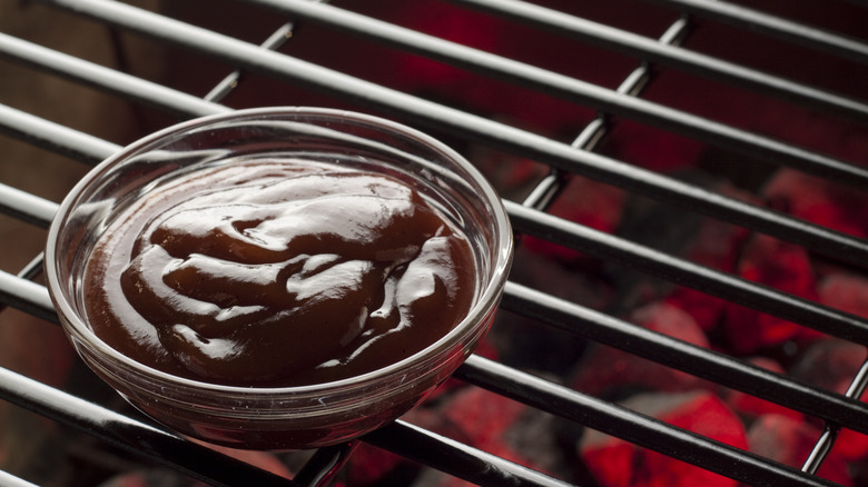 Bowl of barbecue sauce on grill