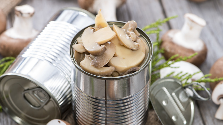 canned mushrooms on wooden background